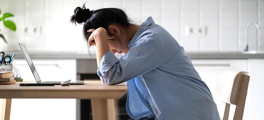 Person experiencing burnout, feeling mentally, emotionally, and physically exhausted at work.